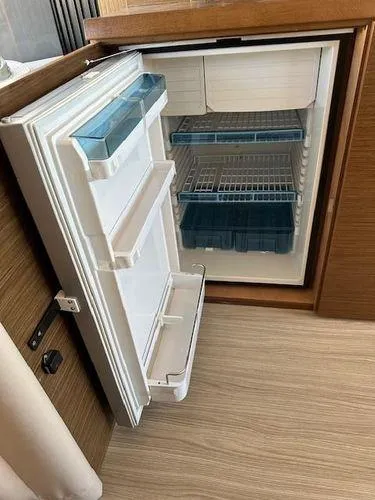 This Could Be Yours Yacht Photos Pics Open refrigerator inside 2023 Bavaria R40 Coupe, showcasing spacious interior and shelving.