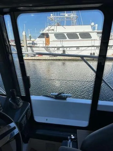 This Could Be Yours Yacht Photos Pics View from inside a 2023 Bavaria R40 Coupe, overlooking a marina with docked boats.