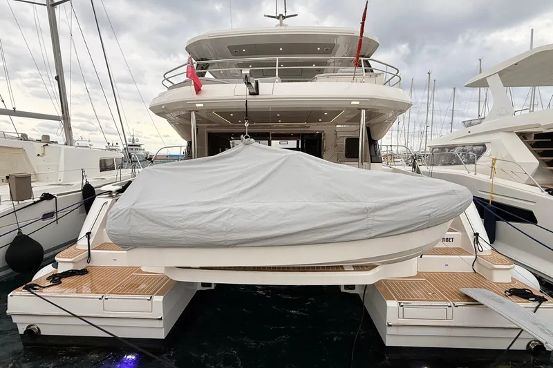  Yacht Photos Pics 2025 Aquila 50 Yacht docked, rear view with covered equipment, cloudy sky.
