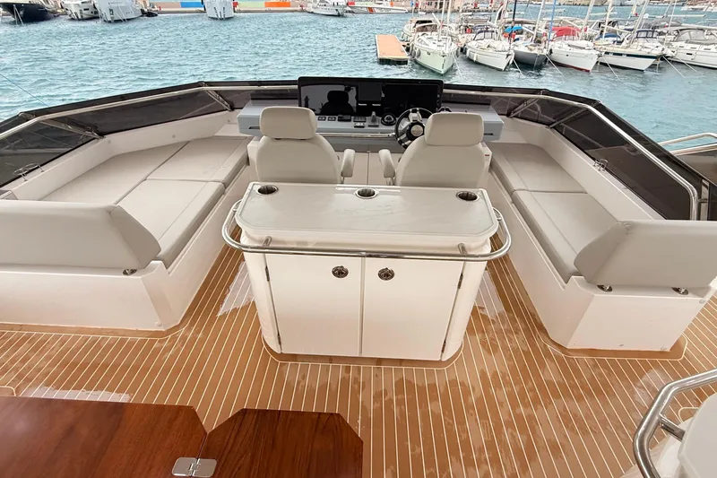  Yacht Photos Pics Luxurious 2025 Aquila 50 Yacht deck with seating and helm, docked at marina.