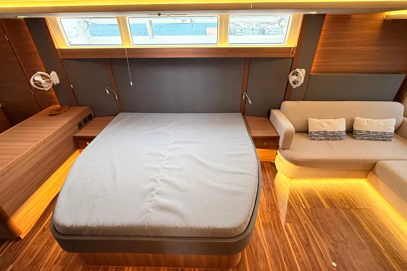  Yacht Photos Pics Luxurious interior of 2025 Aquila 50 Yacht with bed, sofa, and ambient lighting.
