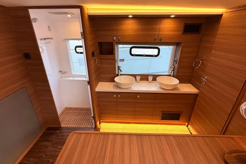  Yacht Photos Pics Luxurious bathroom interior of 2025 Aquila 50 Yacht with dual sinks and wooden cabinetry.