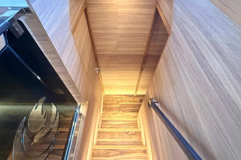  Yacht Photos Pics Staircase with wooden finish inside 2025 Aquila 50 Yacht, featuring sleek design and ambient lighting.