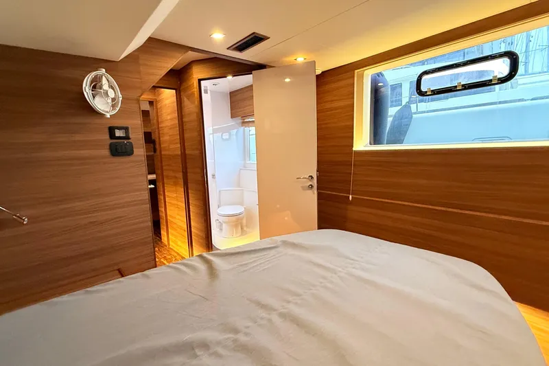  Yacht Photos Pics Luxurious interior of 2025 Aquila 50 Yacht cabin with modern wood finish and ensuite bathroom.