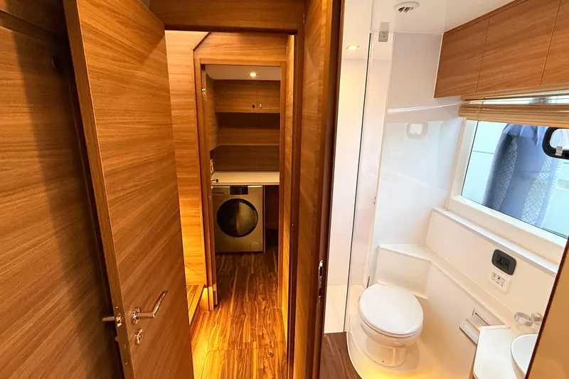  Yacht Photos Pics Luxurious bathroom and laundry area in 2025 Aquila 50 Yacht, featuring wood accents and modern amenities.