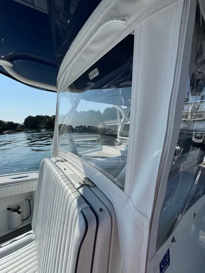 Four Boys Yacht Photos Pics 2014 Yellowfin 36 boat interior with white seating and clear enclosure on a sunny day.