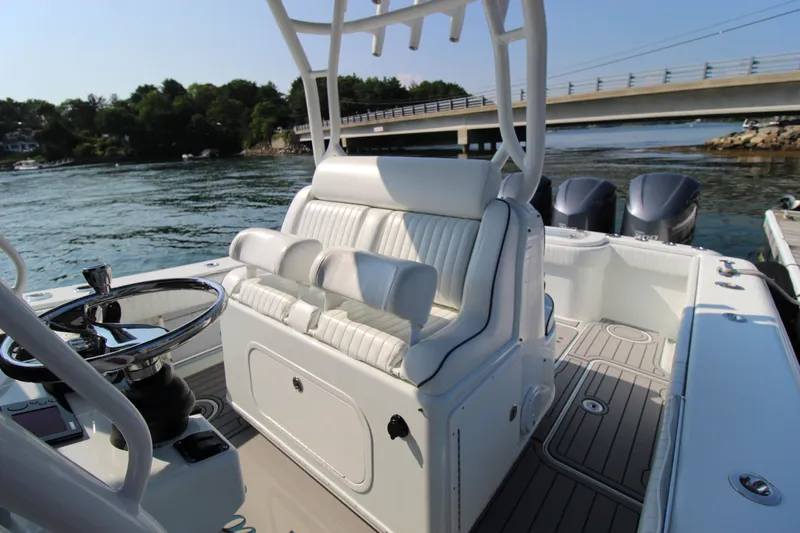 Four Boys Yacht Photos Pics 2014 Yellowfin 36 boat interior with white seating and dual engines near a bridge.