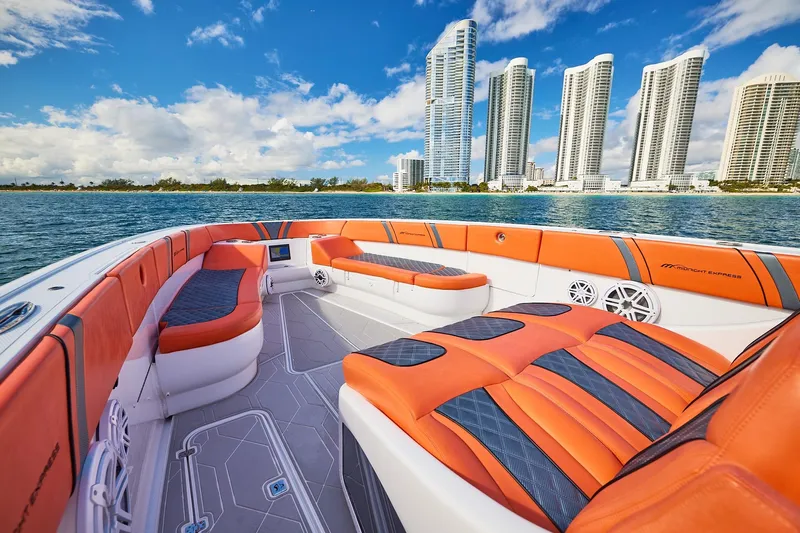  Yacht Photos Pics Luxurious Midnight Express 43 Open boat with vibrant orange seating, city skyline in background.