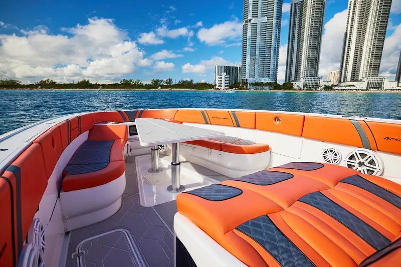  Yacht Photos Pics Luxurious Midnight Express 43 Open boat with vibrant orange seating, city skyline in background.
