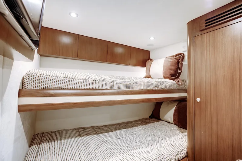 Love Boat Yacht Photos Pics Bunk beds in 2015 Ocean Yachts 64 Convertible cabin, featuring wood paneling and cozy bedding.