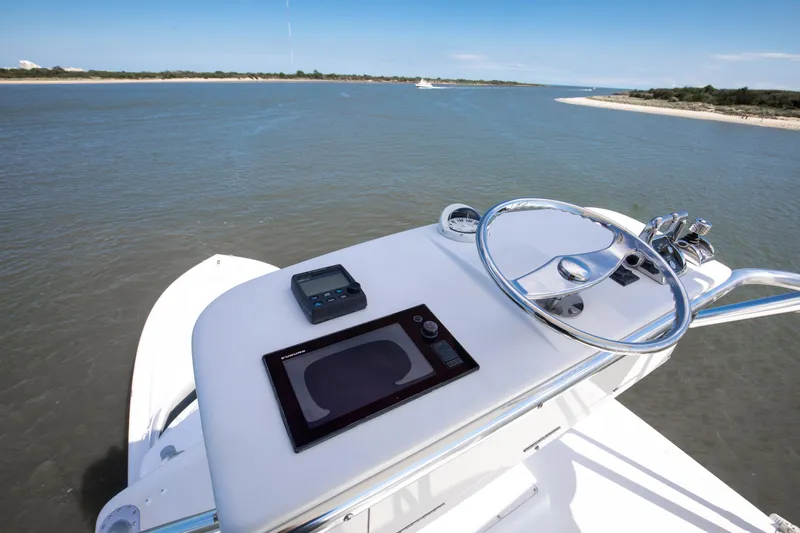 Love Boat Yacht Photos Pics Helm of 2015 Ocean Yachts 64 Convertible, featuring modern navigation equipment and scenic waterway view.