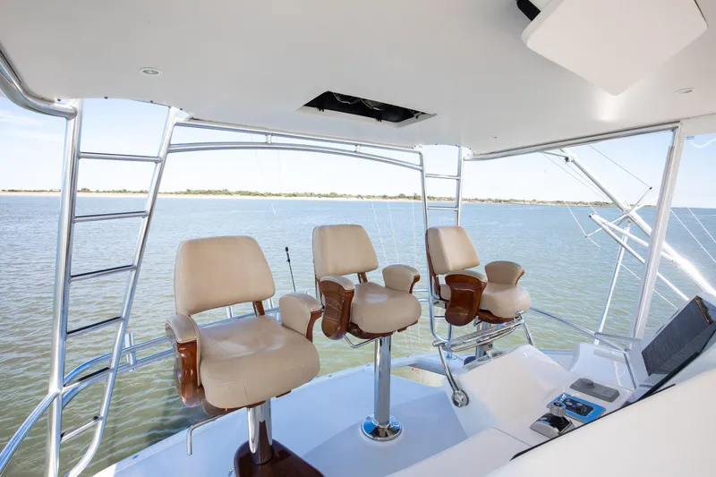Love Boat Yacht Photos Pics Flybridge of 2015 Ocean Yachts 64 Convertible with three captain chairs overlooking the water.