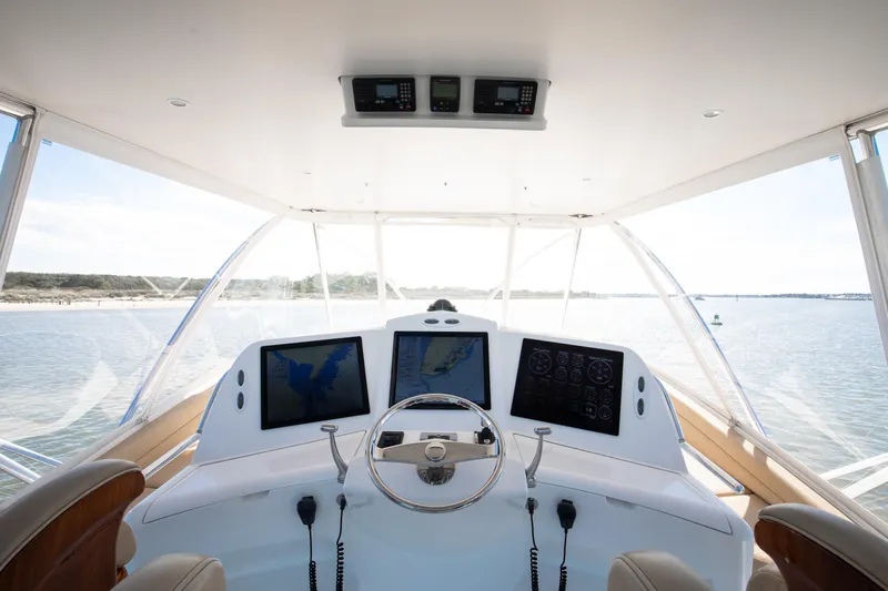 Love Boat Yacht Photos Pics Cockpit view of 2015 Ocean Yachts 64 Convertible, featuring navigation screens and steering wheel.