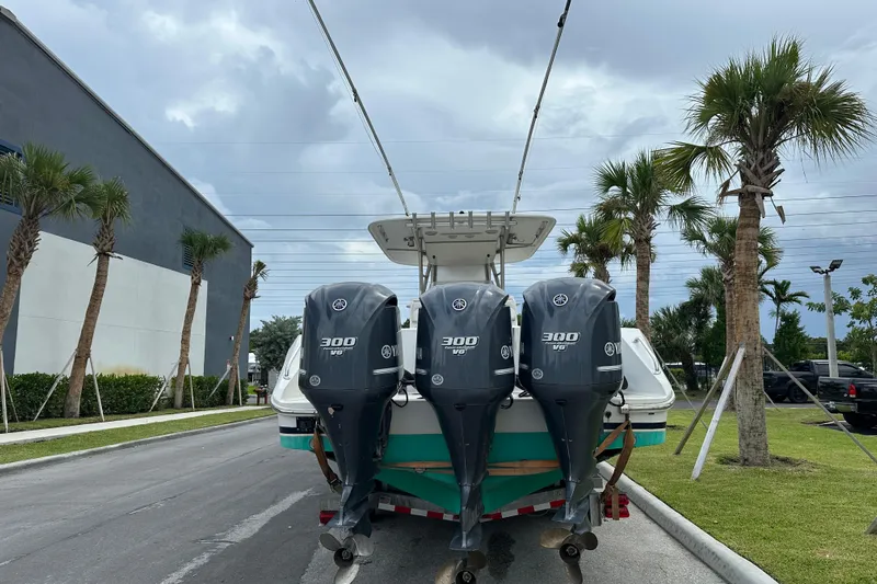  Yacht Photos Pics 2013 Bahama 37CC boat with triple Yamaha 300 V6 engines, parked near palm trees.