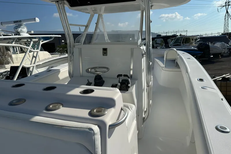  Yacht Photos Pics 2013 Bahama 37CC boat interior with helm, seating, and rod holders under clear sky.