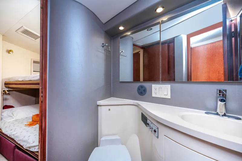 50 Hatteras Convertible Yacht Photos Pics 1992 Hatteras 50 Convertible yacht bathroom with modern fixtures and bunk beds in the background.