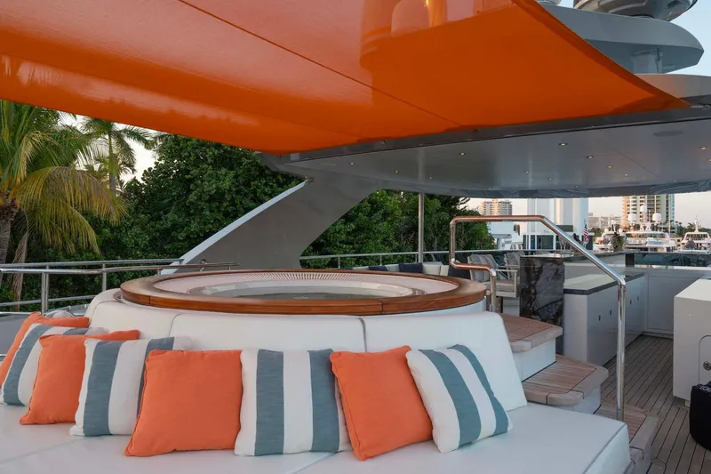 Book Ends Yacht Photos Pics Luxurious 2022 Heesen 5000 yacht deck with jacuzzi, orange canopy, and stylish cushions.