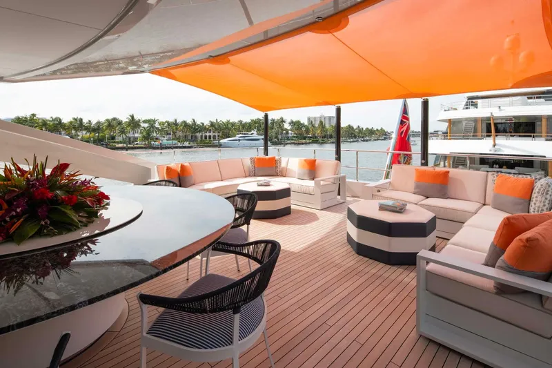 Book Ends Yacht Photos Pics Luxurious 2022 Heesen 5000 yacht deck with elegant seating and vibrant orange canopy.