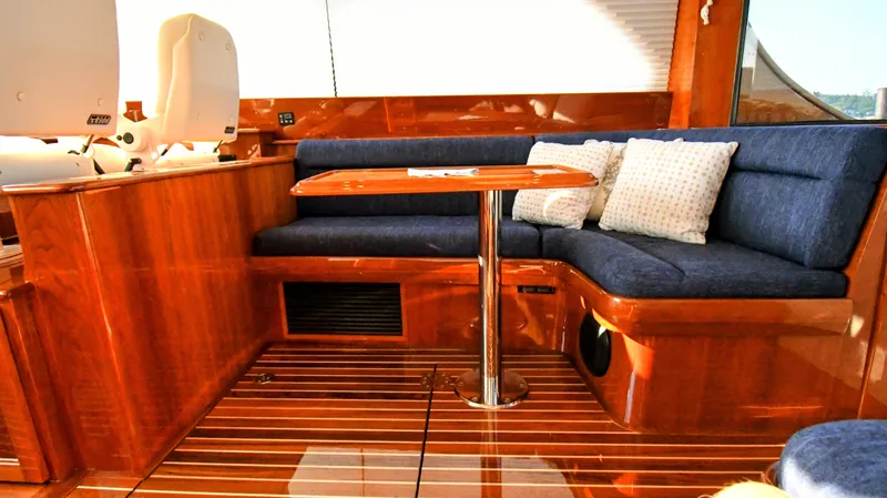 My Lisa Yacht Photos Pics Luxurious interior of 2022 Hinckley Talaria 43 yacht with wooden finish and blue seating.