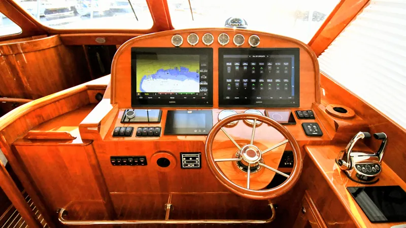 My Lisa Yacht Photos Pics Helm of 2022 Hinckley Talaria 43 yacht with advanced navigation displays and wooden finish.