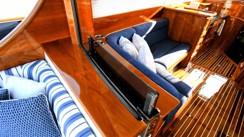 My Lisa Yacht Photos Pics Luxurious interior of 2022 Hinckley Talaria 43 yacht with polished wood and blue seating.