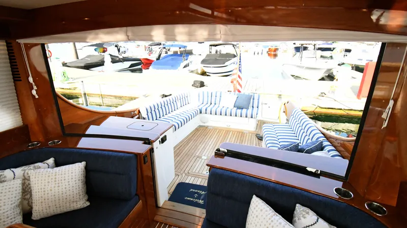 My Lisa Yacht Photos Pics Interior view of 2022 Hinckley Talaria 43 yacht with striped seating and wooden finishes.