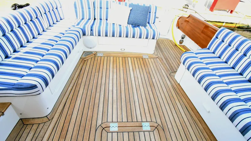 My Lisa Yacht Photos Pics Luxury seating area on 2022 Hinckley Talaria 43 yacht with striped cushions and teak flooring.