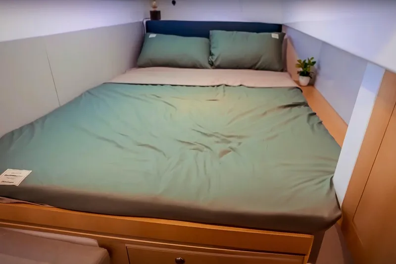 Ruby Rose 2 Yacht Photos Pics Cozy bedroom in 2023 Seawind 1370 yacht with green bedding and potted plant.