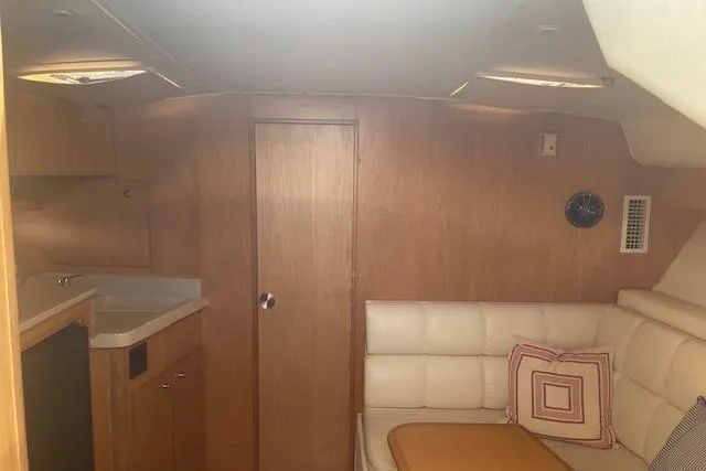 "moxie" Yacht Photos Pics 1998 Tiara Yachts 35 Open Hardtop interior with wood paneling, white seating, and compact kitchenette.