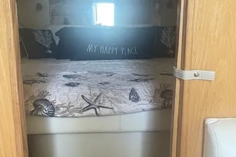 "moxie" Yacht Photos Pics 1998 Tiara Yachts 35 Open Hardtop cabin with cozy bed and nautical decor.