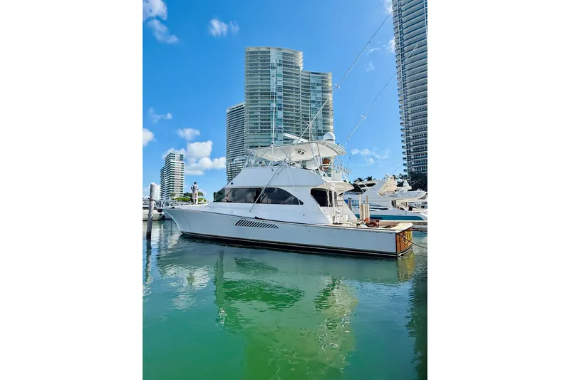 Kickback Yacht Photos Pics 2004 Viking 65 Convertible yacht docked near modern high-rise buildings.