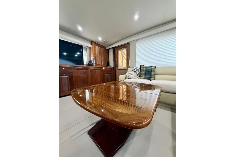 Kickback Yacht Photos Pics Luxurious interior of 2004 Viking 65 Convertible yacht with polished wood table and plush seating.
