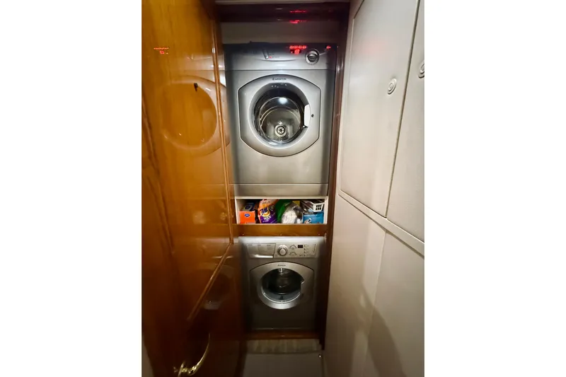 Kickback Yacht Photos Pics Laundry area inside 2004 Viking 65 Convertible yacht with stacked washer and dryer.