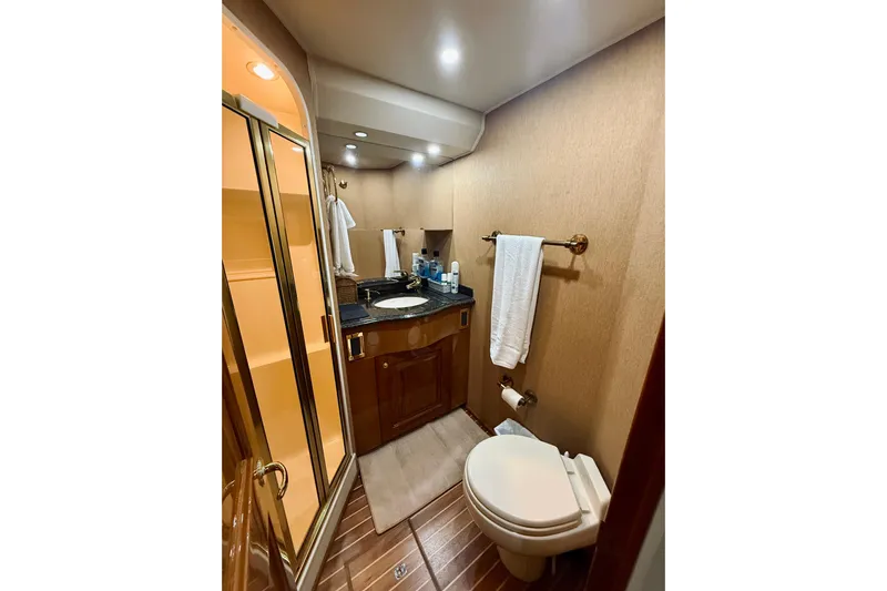 Kickback Yacht Photos Pics Luxurious bathroom in 2004 Viking 65 Convertible yacht with elegant fixtures and wood accents.