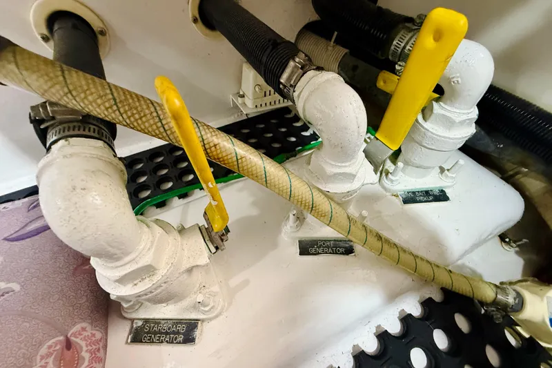 Kickback Yacht Photos Pics Engine room of 2004 Viking 65 Convertible with labeled generator valves and hoses.