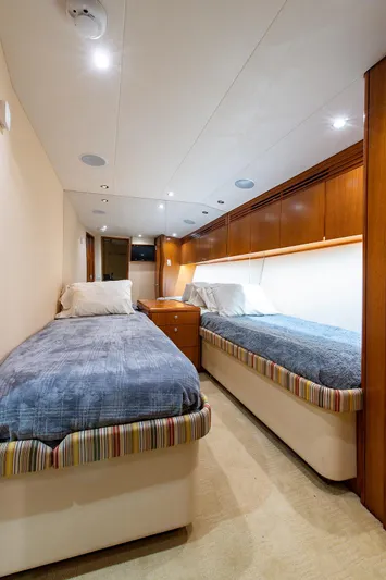  Yacht Photos Pics 2006 Hatteras 64 Convertible yacht cabin with twin beds and wooden cabinetry.