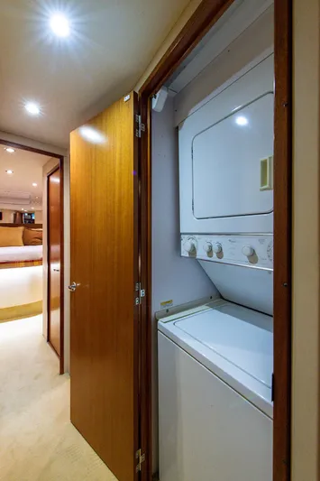  Yacht Photos Pics Laundry area inside 2006 Hatteras 64 Convertible yacht, featuring a stacked washer and dryer.