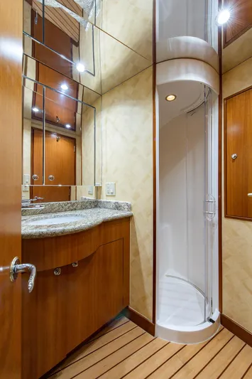  Yacht Photos Pics Luxurious bathroom in 2006 Hatteras 64 Convertible yacht with modern shower and wooden cabinetry.