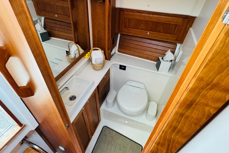  Yacht Photos Pics Luxurious 2025 Back Cove 34O yacht bathroom with wooden cabinetry and modern fixtures.