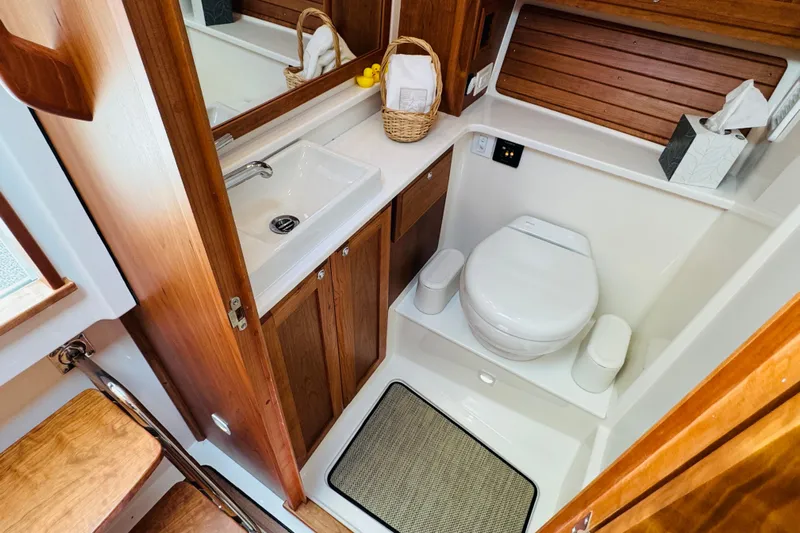  Yacht Photos Pics Bathroom interior of 2025 Back Cove 34O boat, featuring wooden cabinetry and modern fixtures.