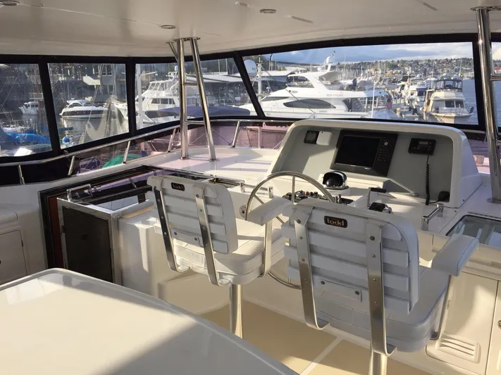 Ardreen Yacht Photos Pics Helm of 2005 Selene 62 Ocean Trawler with marina view, featuring dual captain chairs and navigation equipment.