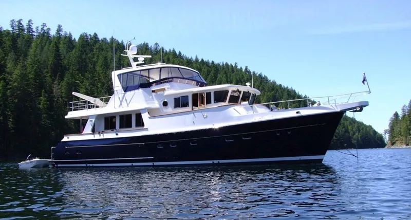 Ardreen Yacht Photos Pics 2005 Selene 62 Ocean Trawler yacht on calm water, surrounded by lush forest.