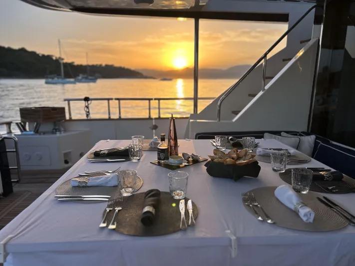 Lady Amanda Yacht Photos Pics Elegant dining setup on 2006 Couach 2800 yacht at sunset.