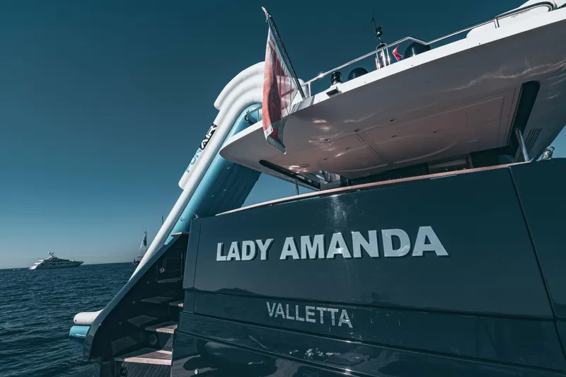 Lady Amanda Yacht Photos Pics Couach 2800 yacht "Lady Amanda" from 2006, docked with a visible slide and flag.