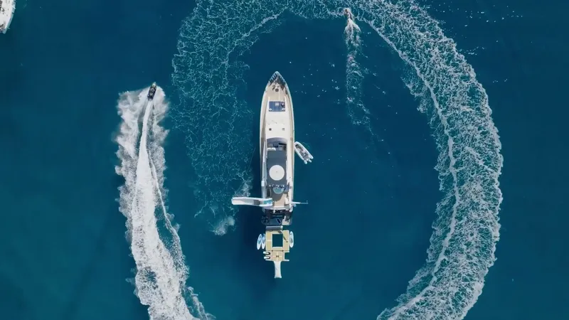 Lady Amanda Yacht Photos Pics Aerial view of 2006 Couach 2800 yacht with jet ski circling in blue ocean.