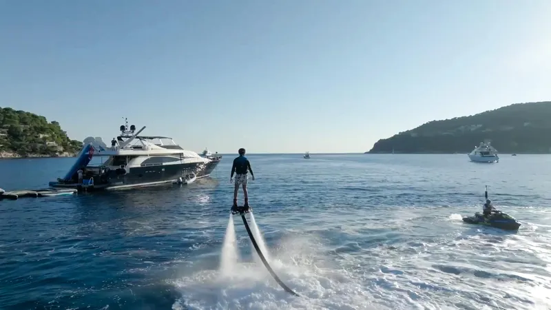 Lady Amanda Yacht Photos Pics Person flyboarding near a 2006 Couach 2800 yacht on a sunny day.
