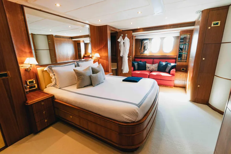 Lady Amanda Yacht Photos Pics Luxurious bedroom in 2006 Couach 2800 yacht with elegant wood finishes and cozy seating area.