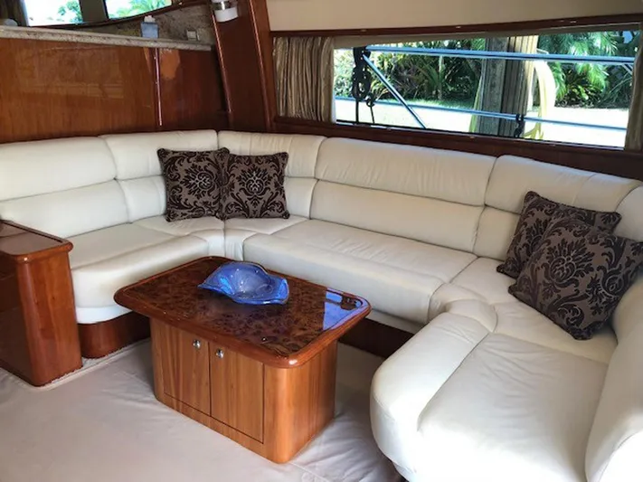 Amarone Yacht Photos Pics Luxurious interior of 2008 Neptunus 62 Motoryacht with elegant white leather seating and wooden table.