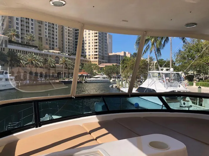 Amarone Yacht Photos Pics 2008 Neptunus 62 Motoryacht interior with marina view, palm trees, and waterfront buildings.