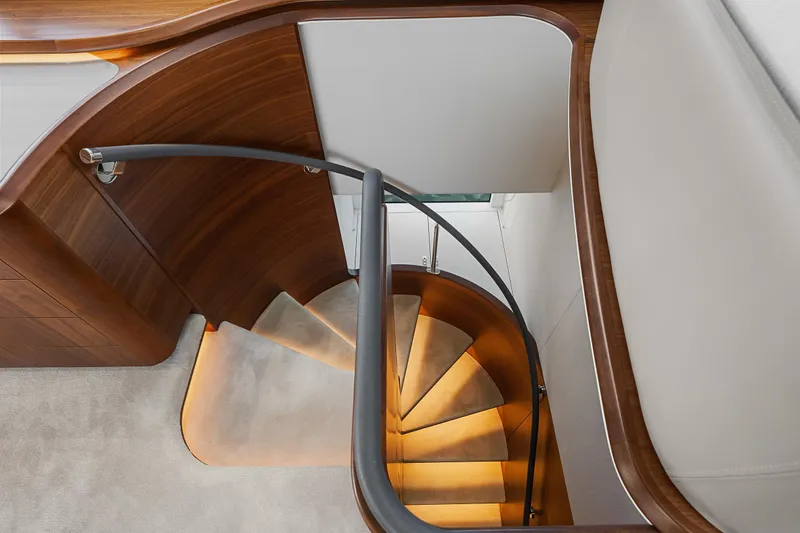 S72515 Yacht Photos Pics Elegant spiral staircase in 2023 Princess S72 yacht with wooden finish and modern design.